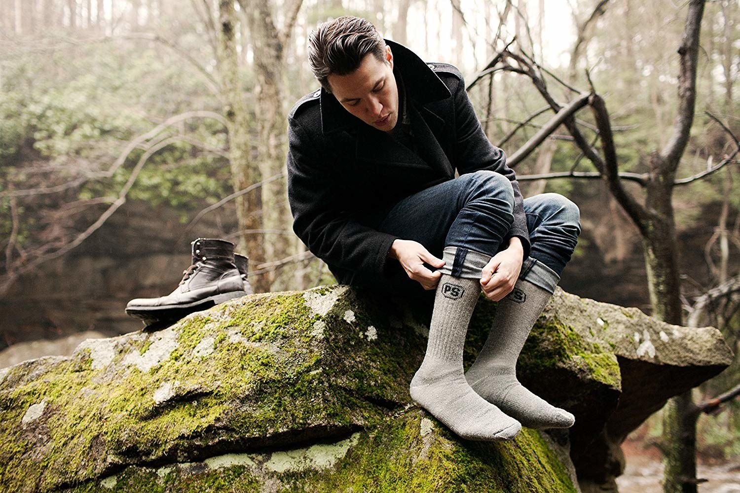 A model putting on the crew height grey wool socks