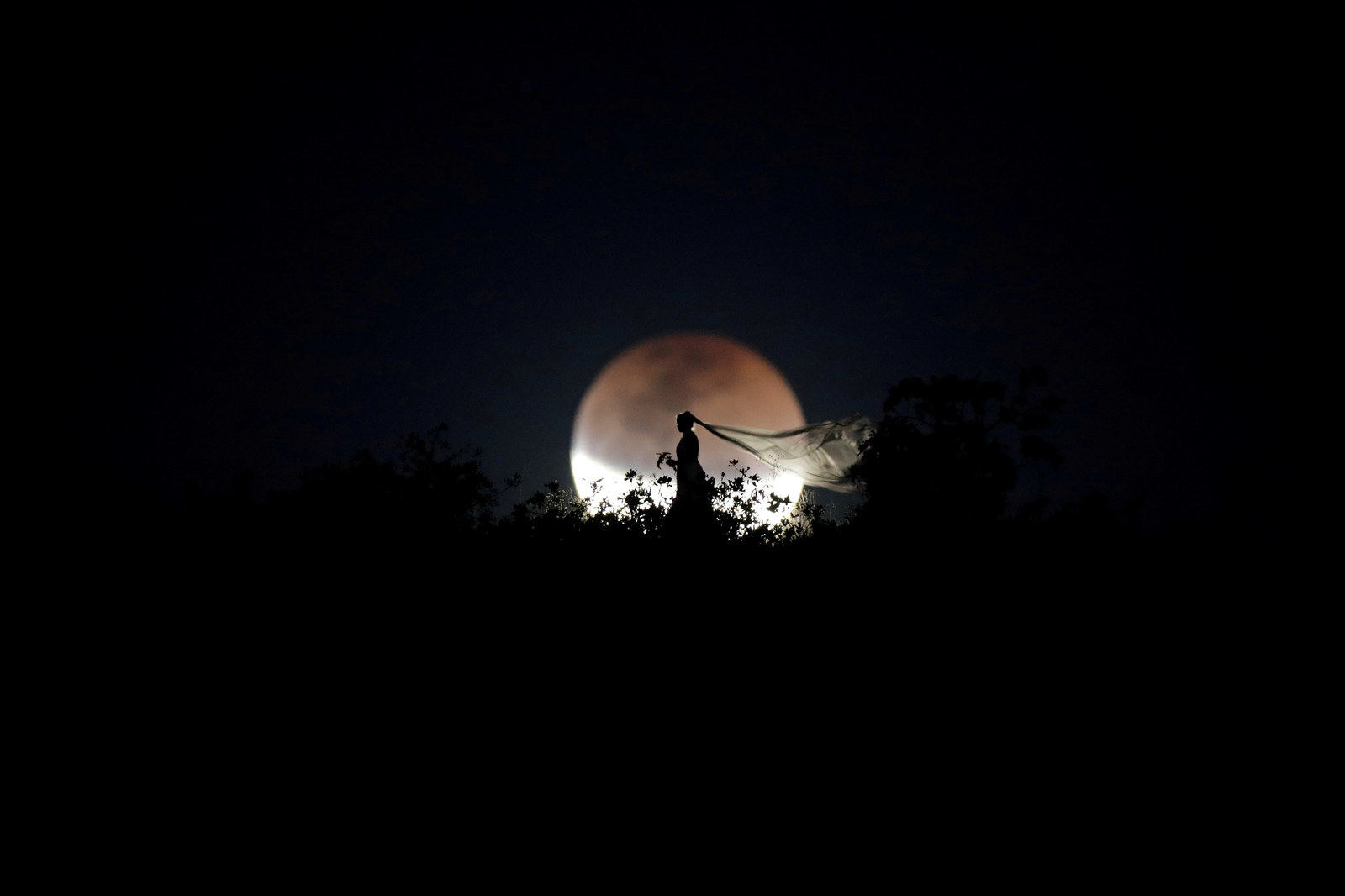 Brasilia, Brasil, 27 de julio - Una novia posa para una foto durante el eclipse lunar.