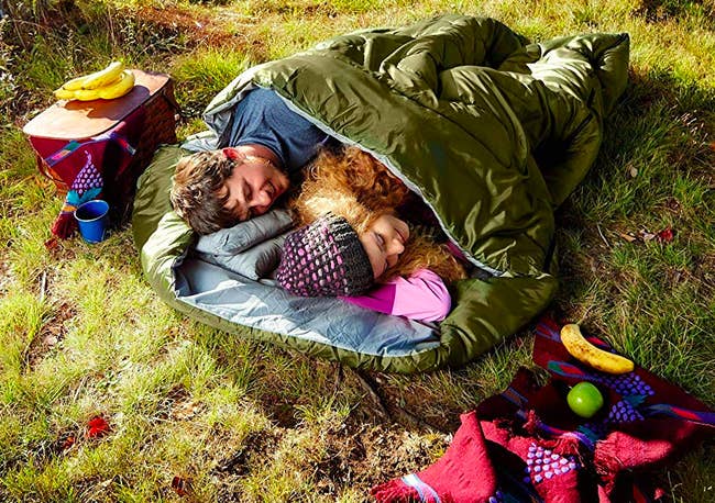 Two people sleeping side-by-side in large sleeping bag 