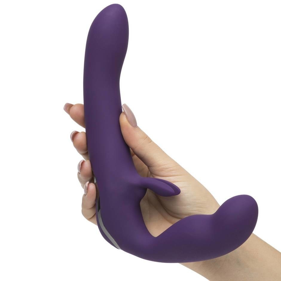 a hand holding the purple strapless strap-on