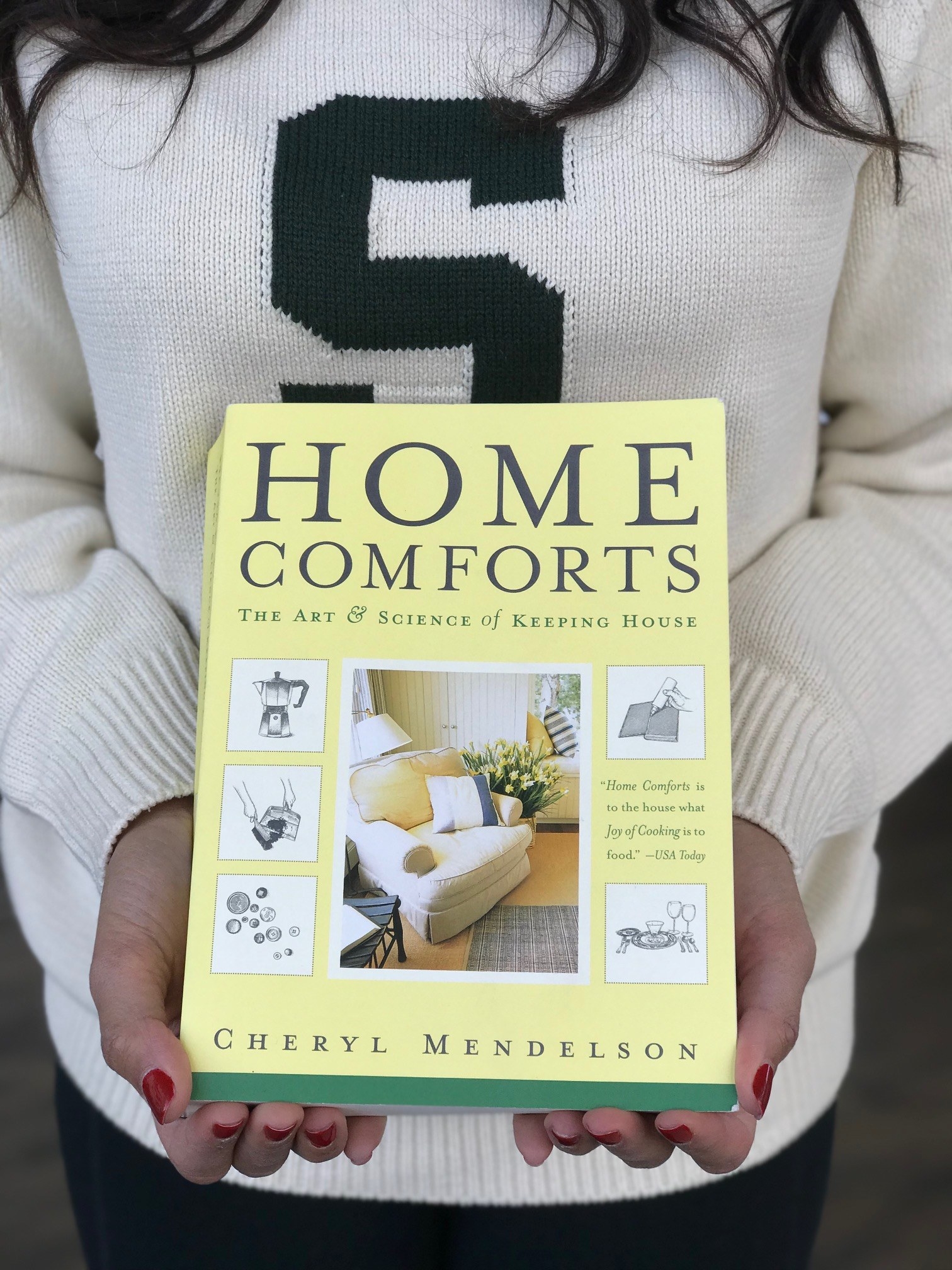 Person holding Home Comforts reference book