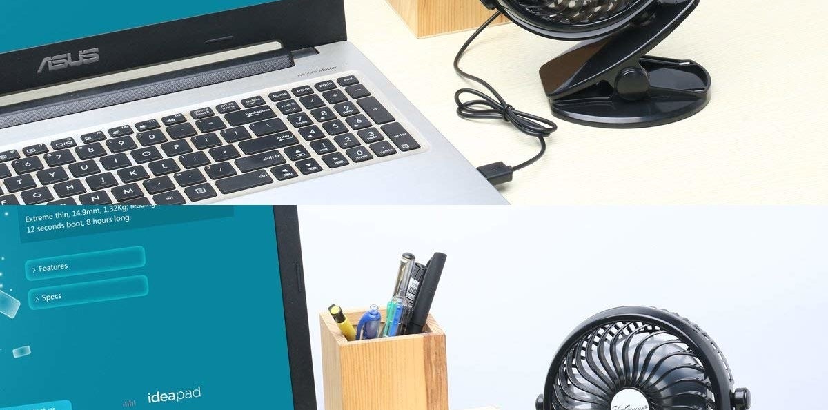 desk with laptop with small size fan clipped onto edge of desk 