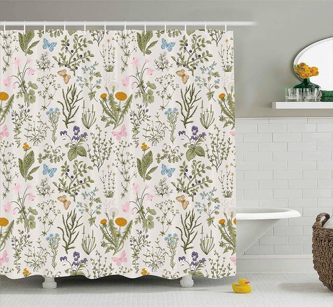 the off-white shower curtain featuring butterflies, leaves, berries, and flowers 