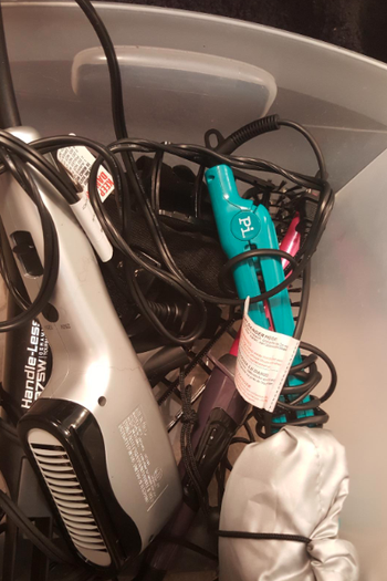 before: reviewer's bin of tangled hair styling tools