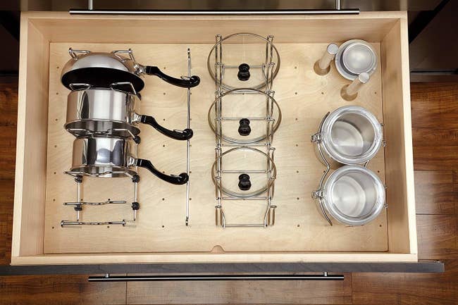 open kitchen drawer with a peg board bottom and adjustable organizers to hold pans and lids