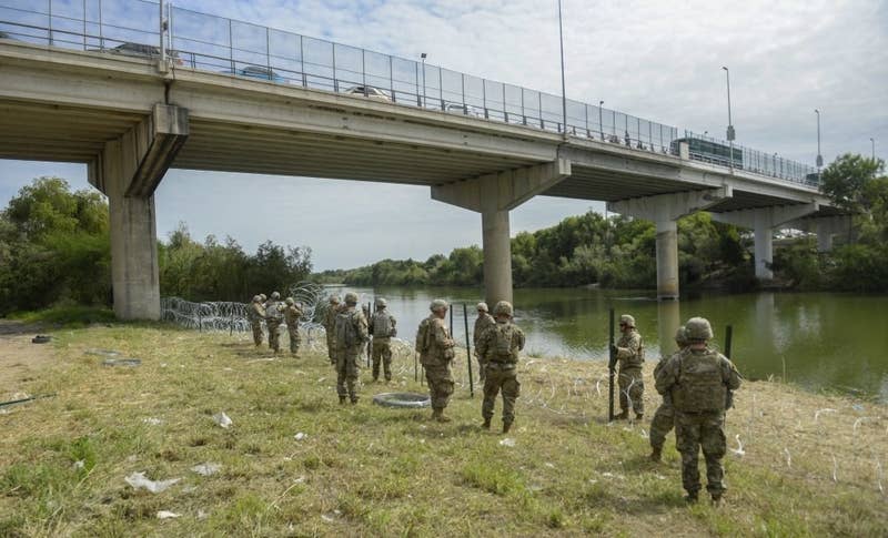 Soldiers from the 97th Military Police Battalion and the 41st Engineer Company from Fort Riley, Kansas, string concertina wire near the Mexican border.