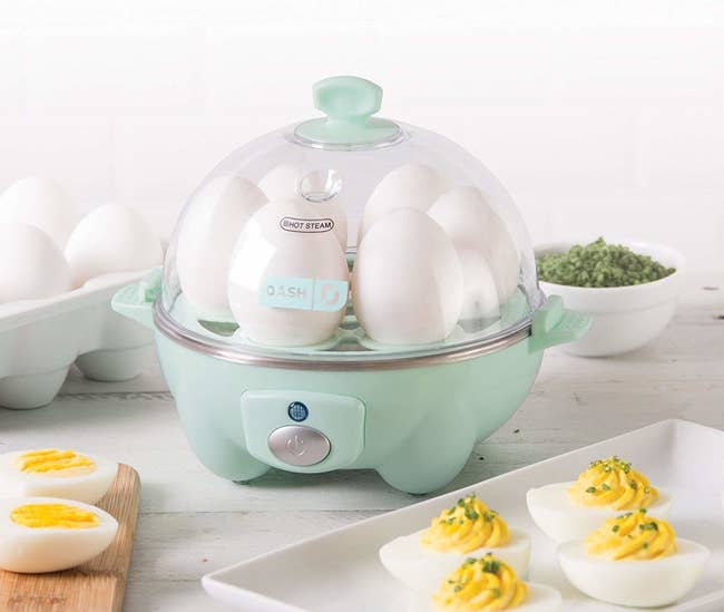 an aqua egg cooker full of six eggs