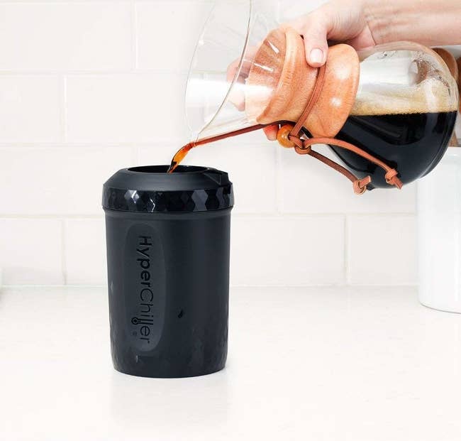 A person pouring coffee into the drink-chilling vessel