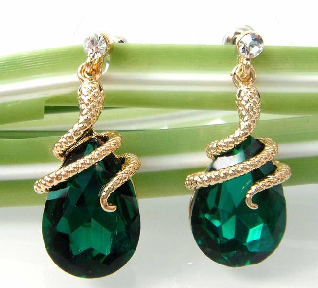 The dangle earrings with teardrop green stones and snakes wrapped around the top