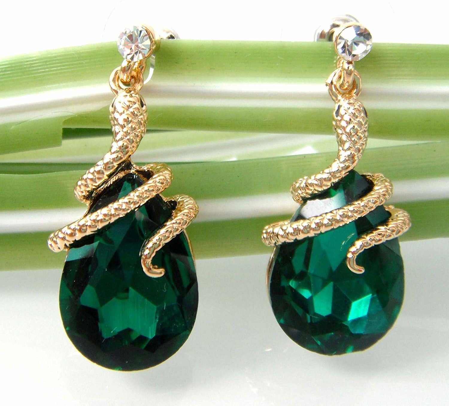 The dangle earrings with teardrop green stones and snakes wrapped around the top