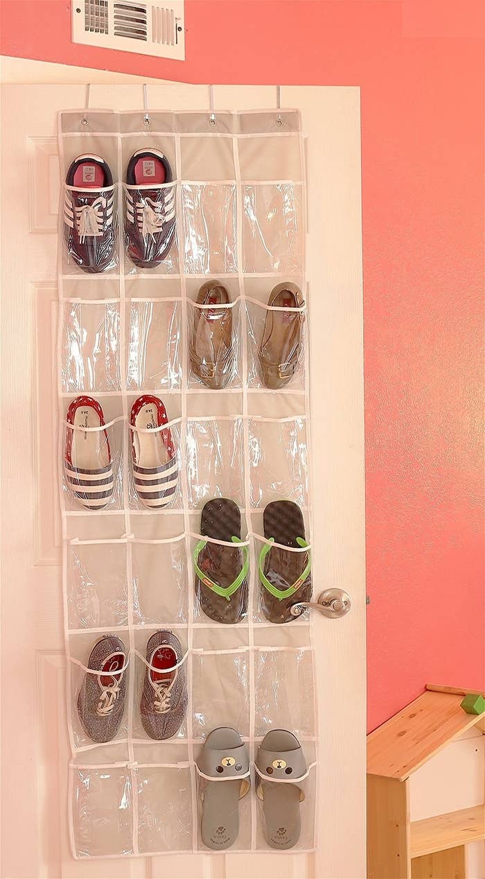 closet door with hanging plastic clear organizer on it with storage pockets for shoes
