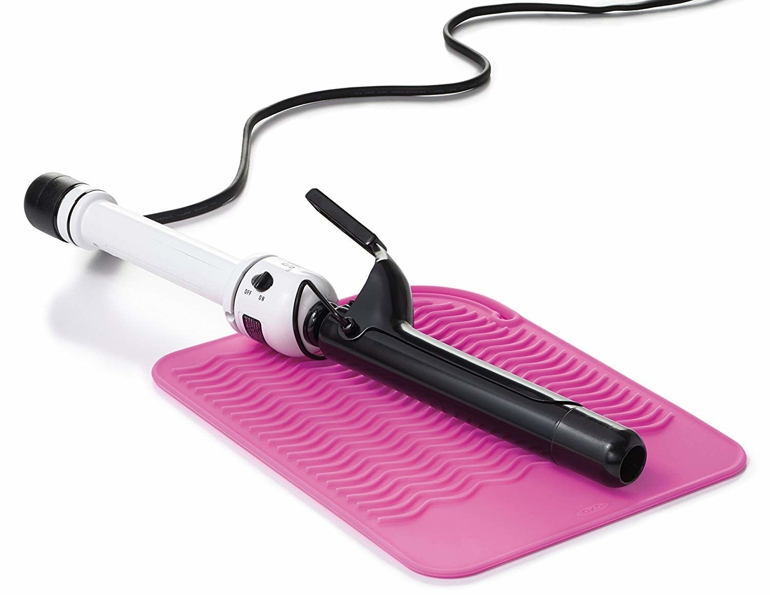 curling iron laying on textured hot pink silicone mat