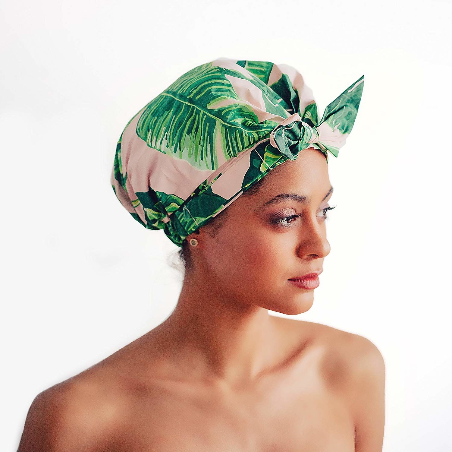 person wearing a palm leaf print shower cap