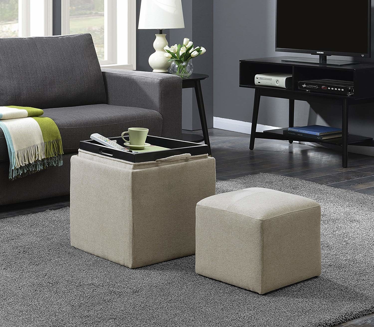 the storage ottoman with a tray on top and smaller ottoman next to it 