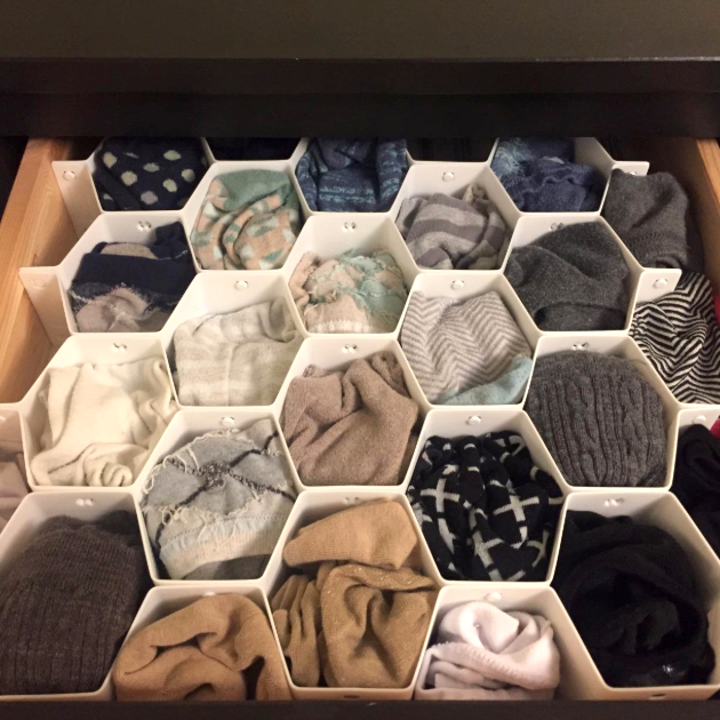Reviewer's "after" picture of their tidy sock drawer with a pair of socks in each compartment of the organizer 