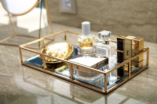 Tray on counter with perfume and makeup inside