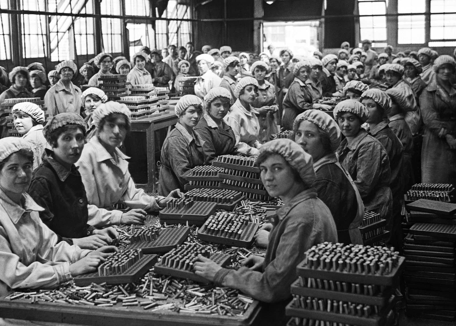 Munition workers finish small-arms cartridges at the Woolwich Arsenal in London, 1918.