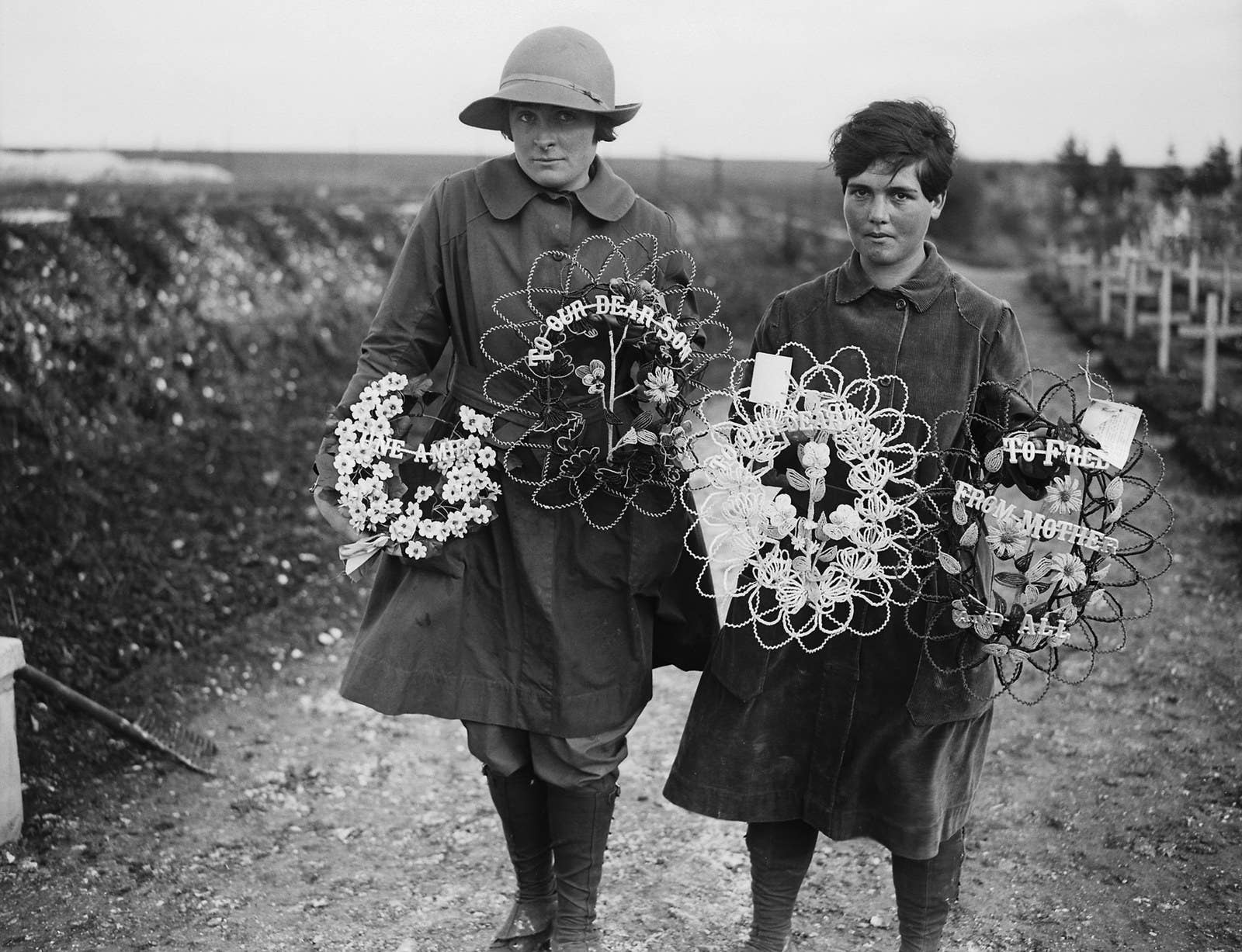 Two members of the Women&#x27;s Auxiliary Army Corps carrying wreaths to place on the graves of British soldiers buried at Abbeville, France, 1918.