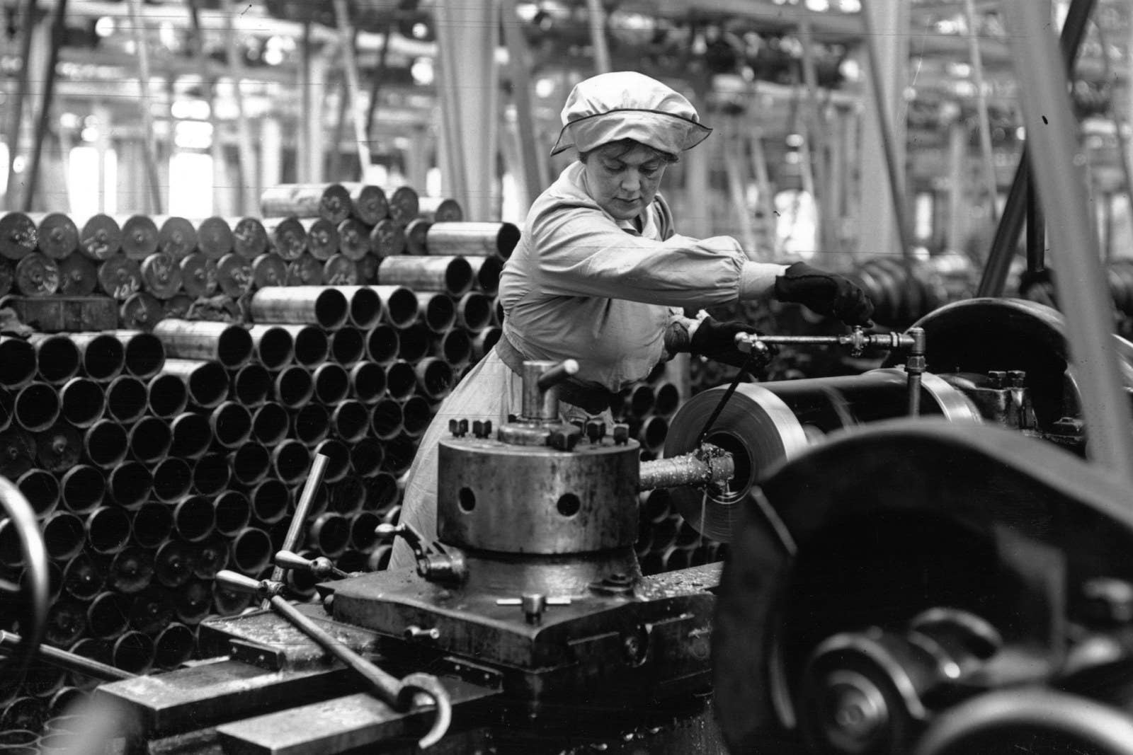 A munitions worker operating a machine in an armaments factory, circa 1915.