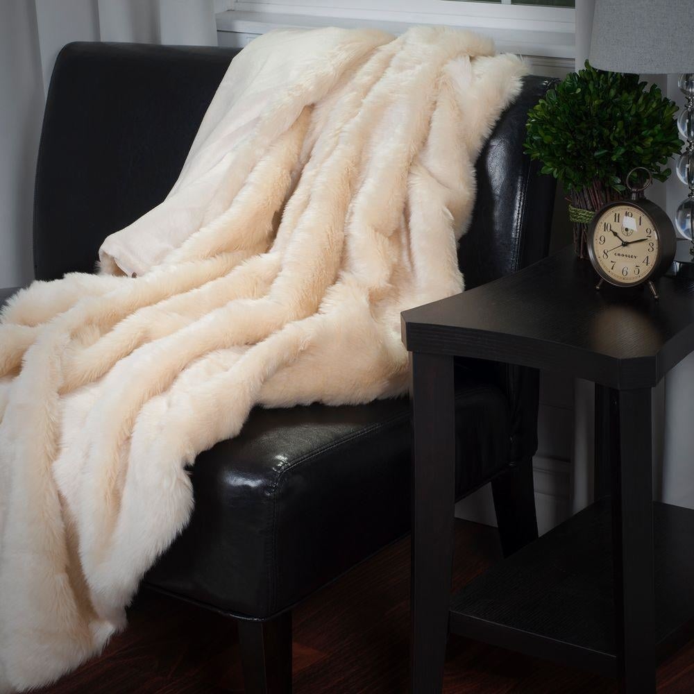 Promising review: "This throw is as luxurious as it looks! The fur is long, soft, and supple. It stays put wherever you place it without it sliding off onto the floor. It's the best throw I've ever invested in. It's keeping us warm on these cold winter nights and looks beautiful and rich, as well." —JulieBGet it from Home Depot for $37.02.