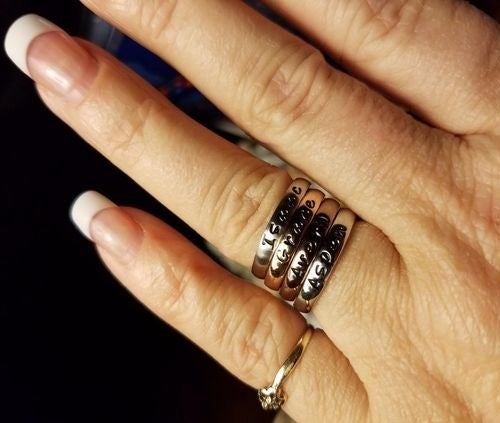 reviewer wearing four stacked engraved rings
