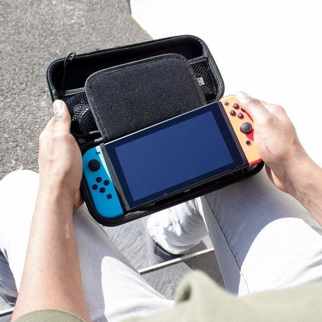 a model taking their switch out of the simple black carrying case