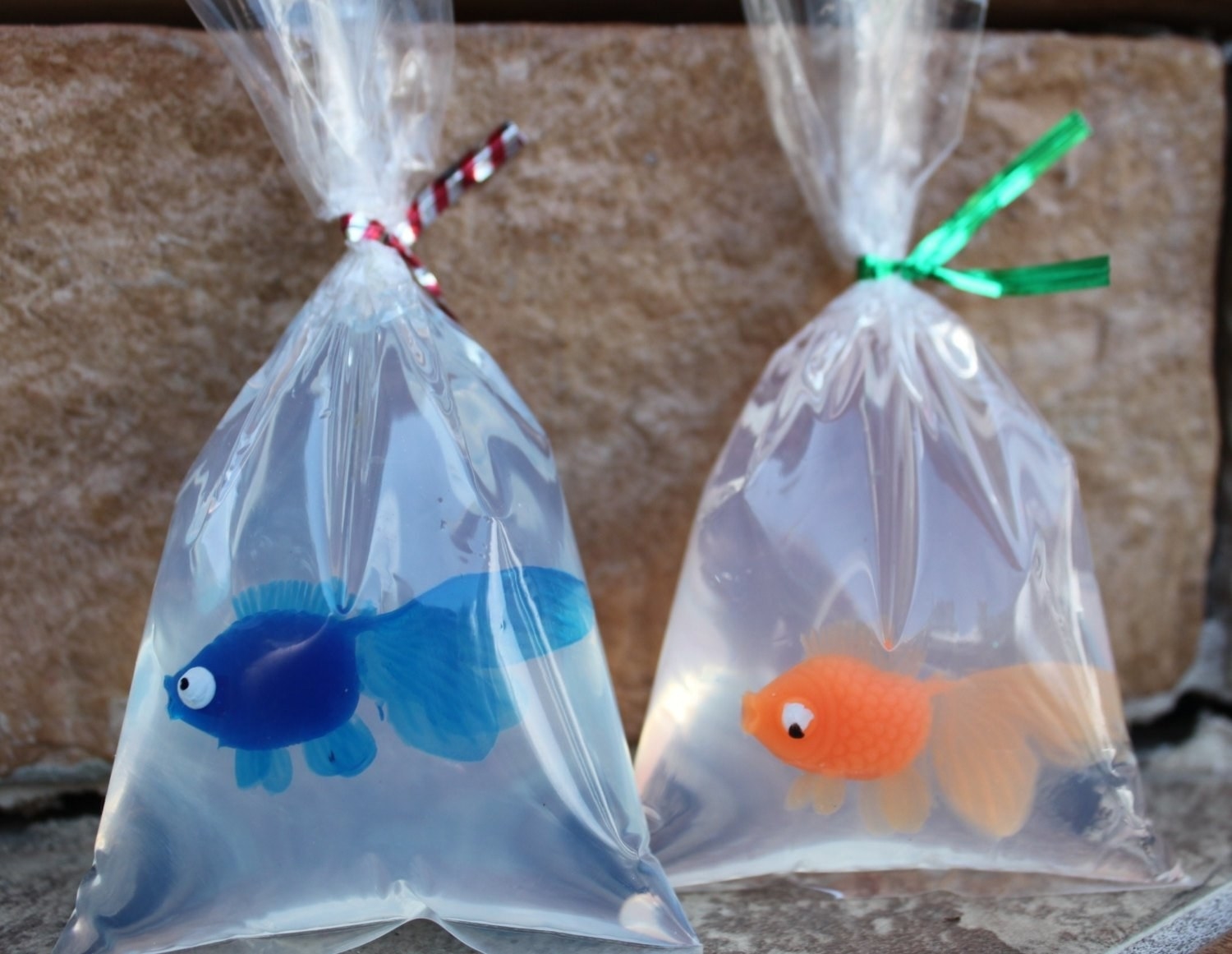 two soaps in bags with plastic goldfish inside 