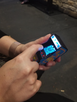 a reviewer playing with the tiny arcade game