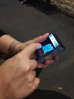 a reviewer playing with the tiny arcade game
