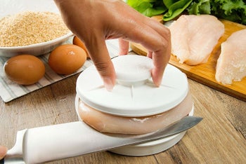The tool being used to slice raw chicken breast