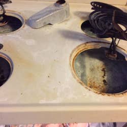 reviewer's white stovetop with tons of rusty stains