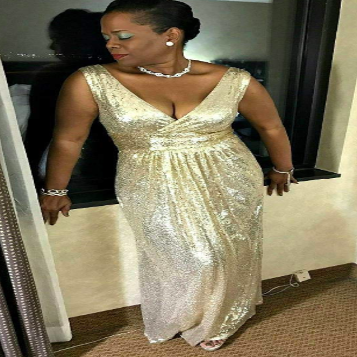 A reviewer wearing the gown in gold