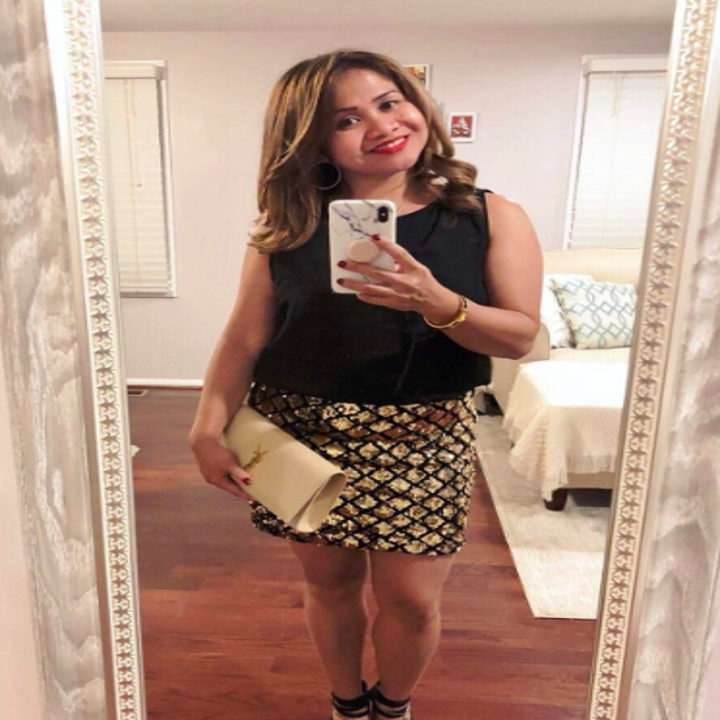 A reviewer wearing the dress with a gold sequined bottom. The sequins are in a grid style that almost looks like scales