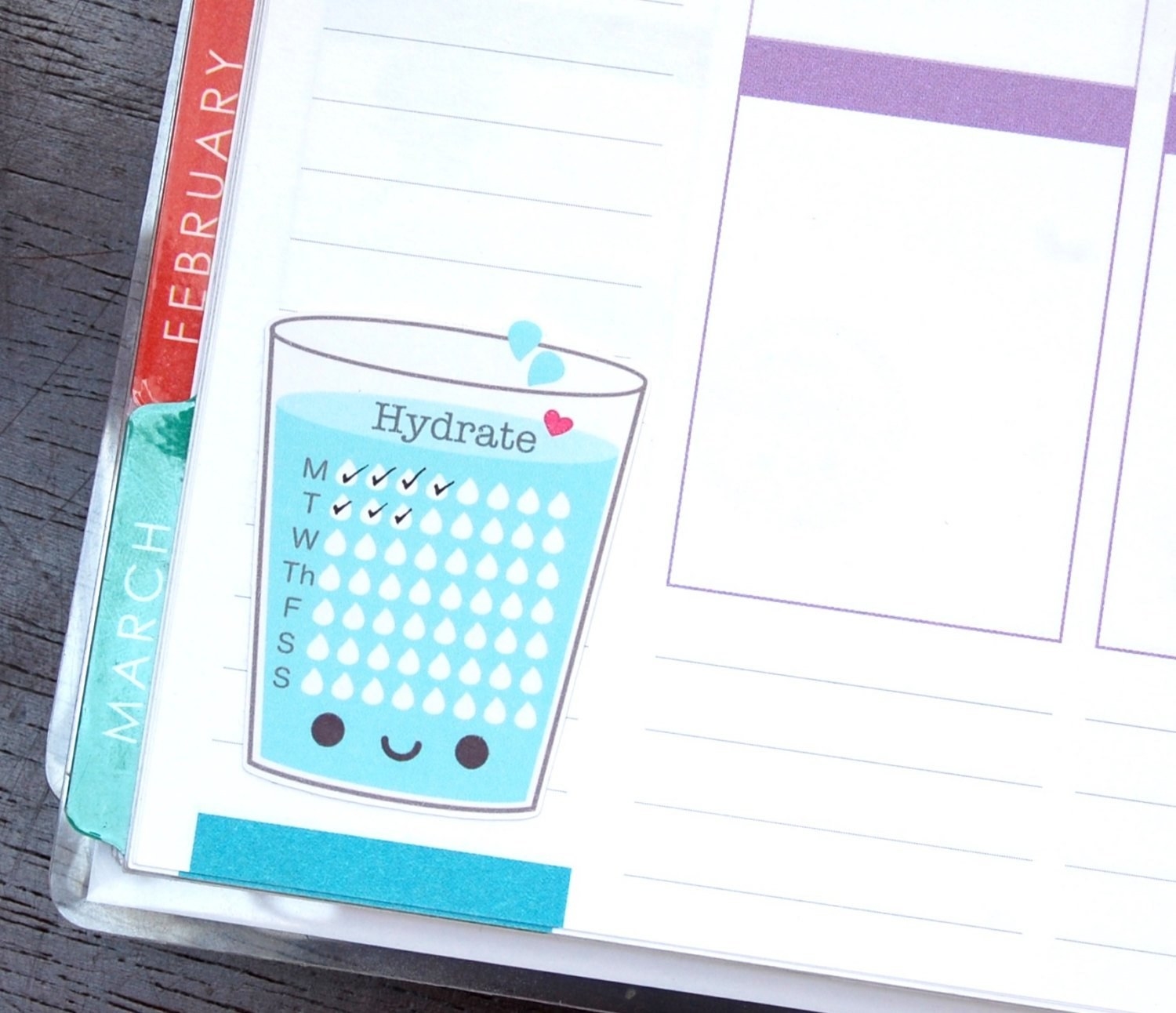 water glass shaped sticker with eight droplet shaped checkmarks for each day of the week on a planner page