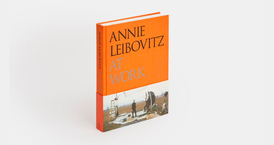 book title in black and grey with orange background above a photo of annie leibovitz on a photoshoot
