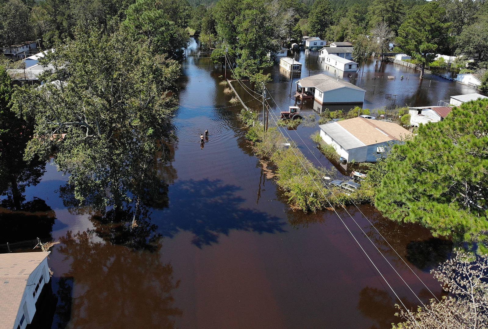 Jovani Quintano and Carlos Gomez walk through a flooded neighborhood after heavy rains brought on by Hurricane Florence, Sept. 19, in Lumberton, North Carolina.