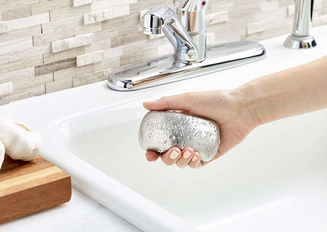 Hand holding the stainless steel in the shape of a bar of soap