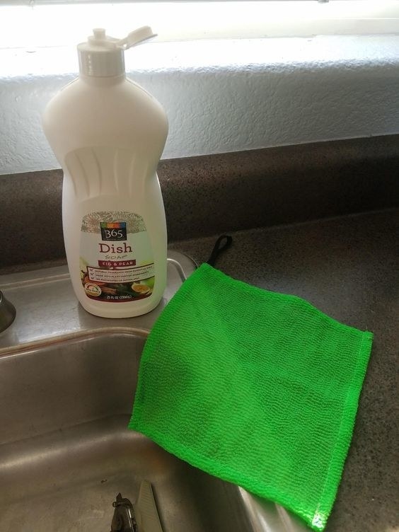 A reviewer&#x27;s green scrubbing cloth on the edge of their sink