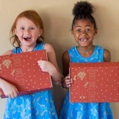 Two child models holding their crate