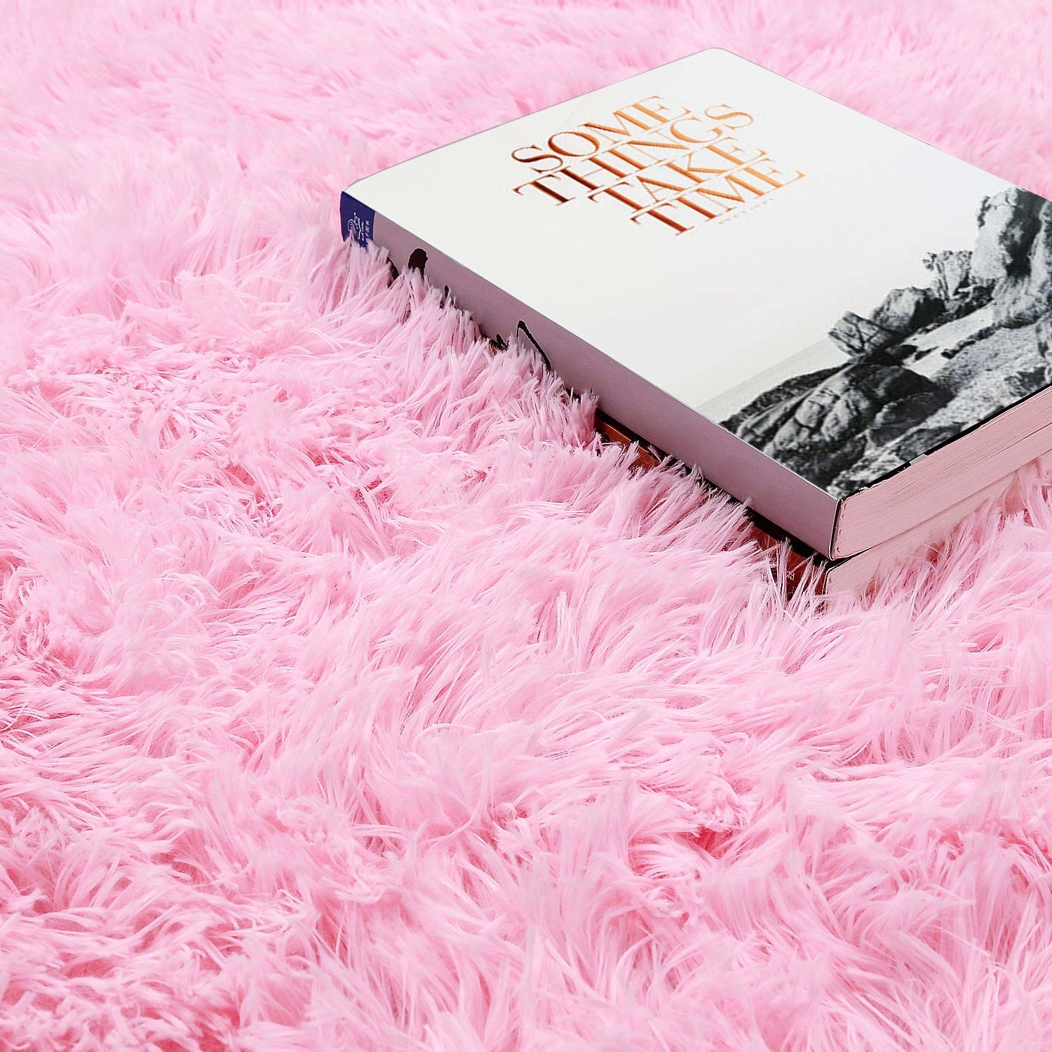 pink shag rug with a coffee table book on it