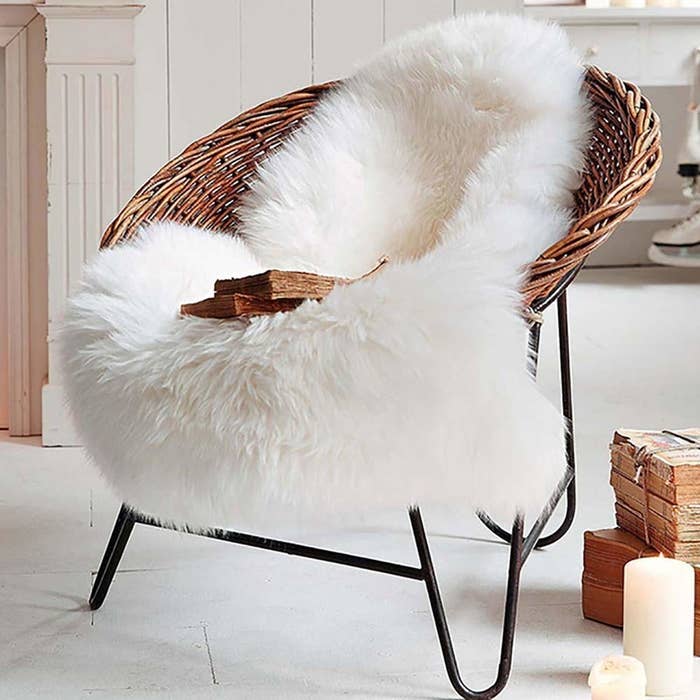 wicker chair with white faux sheepskin rug thrown on it