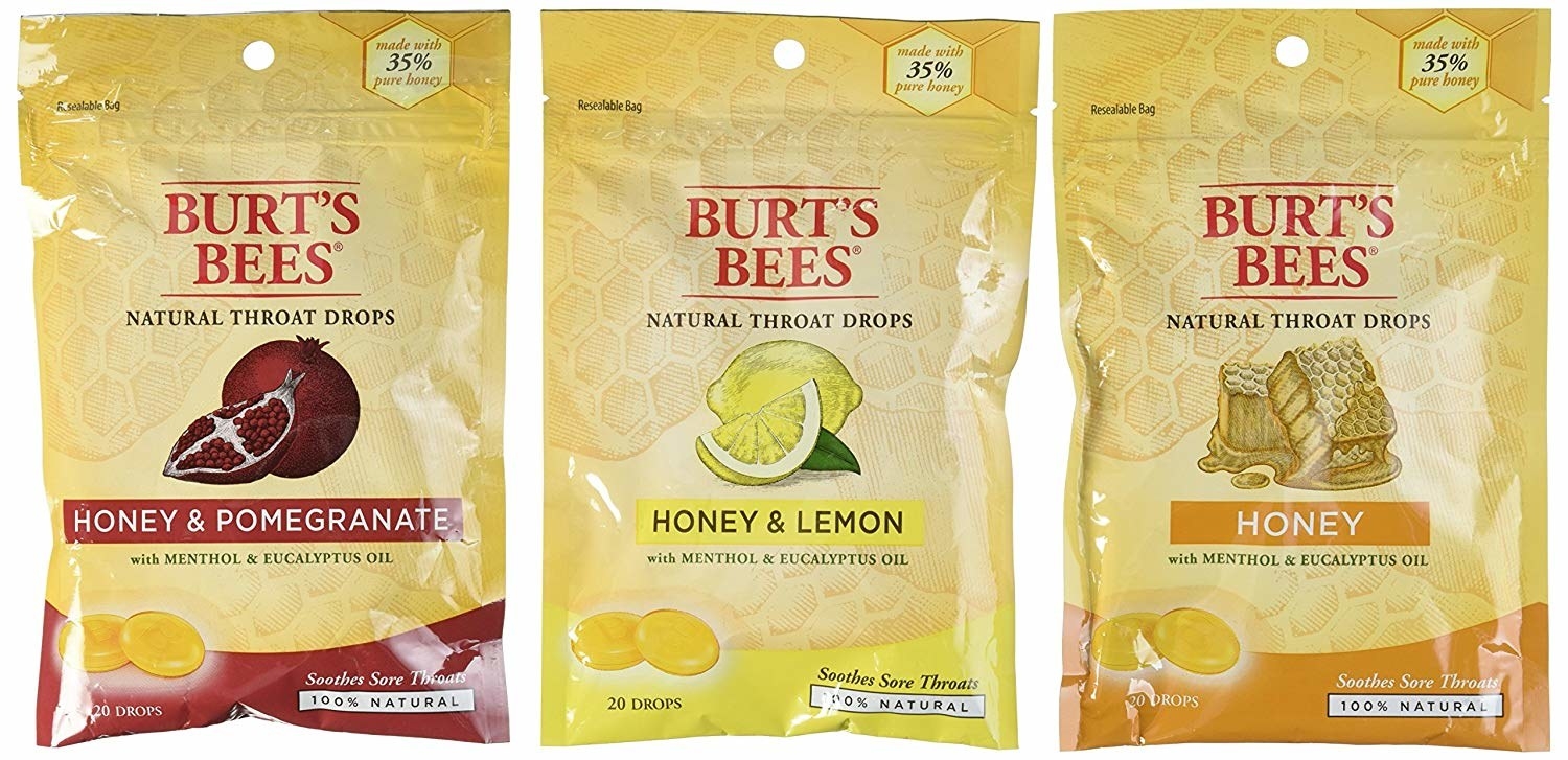 Three yellow packs of Burt&#x27;s Bees natural throat drops of different flavors.