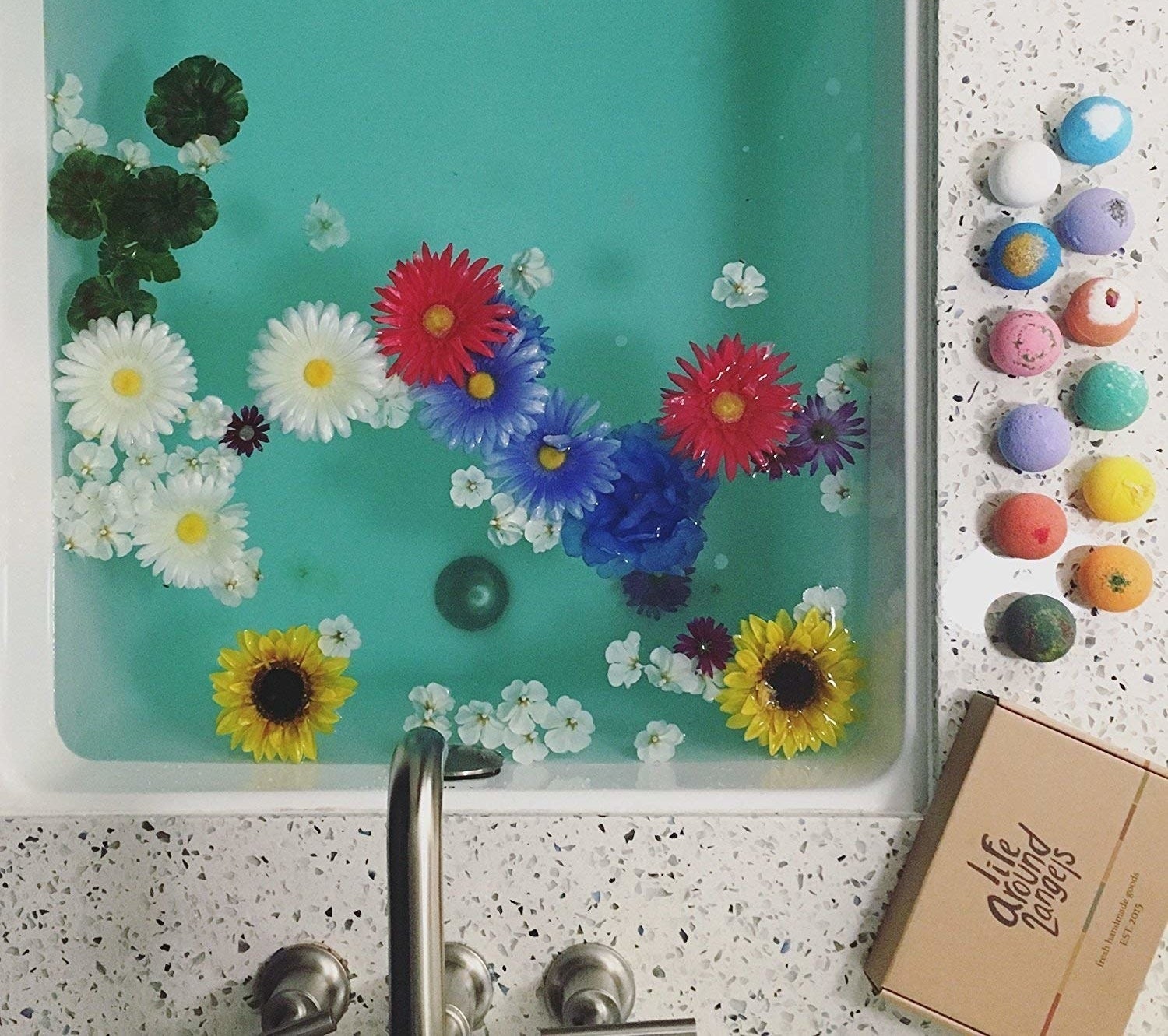 bath tub with flowers in it and bath bombs on the side 