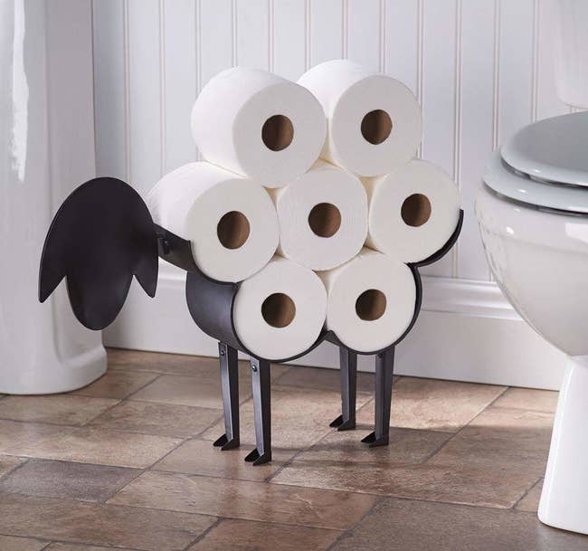 metal sheep holder with seven rolls of toilet paper that look like its wool