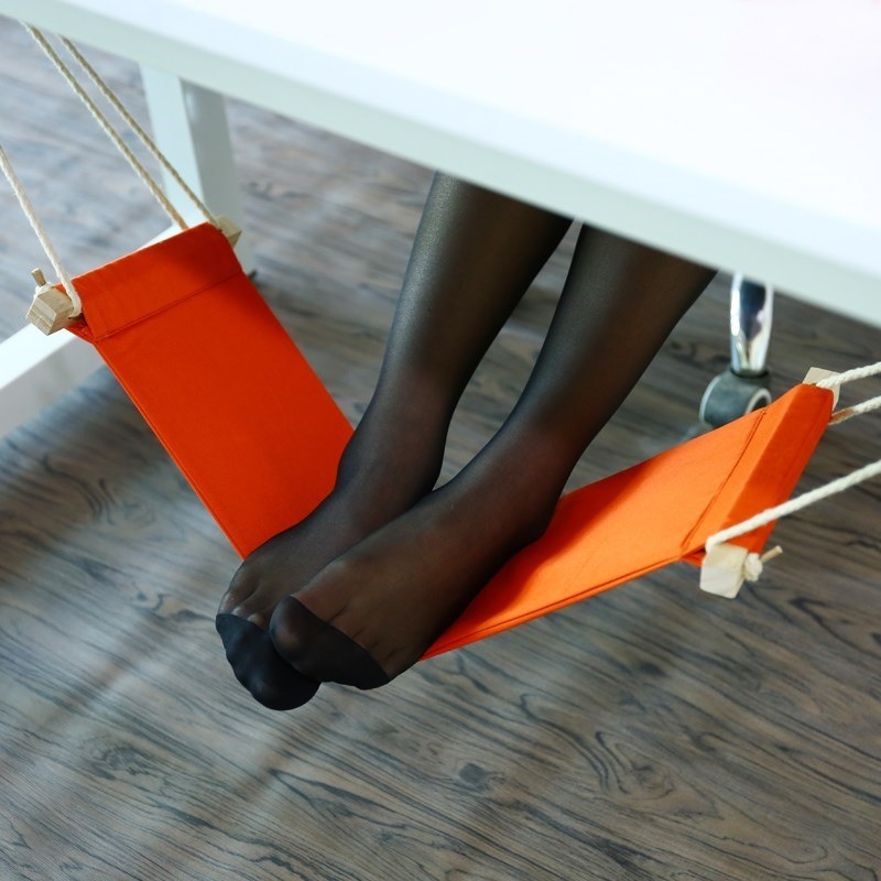 Model using foot hammock under desk