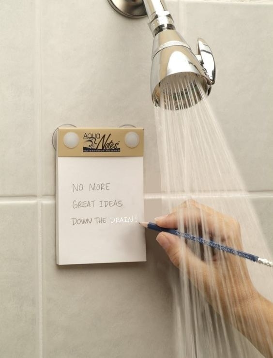 model writing on a note pad suctioned to a shower wall
