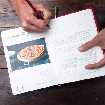 inside of the recipe book with a picture of food taped to the page