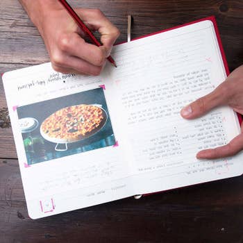 inside of the recipe book with a picture of food taped to the page 