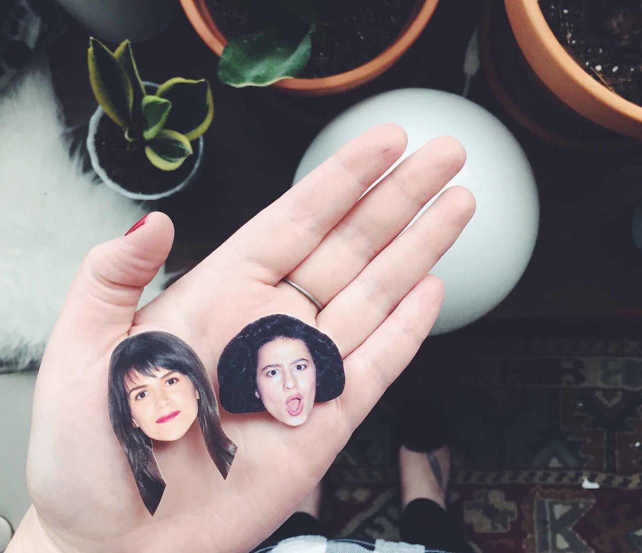 small magnets of ilana glaser and abbi jacobson&#x27;s faces in someone&#x27;s hand