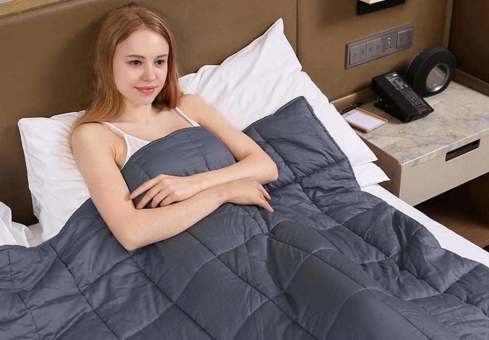 person in bed under a weighted blanket
